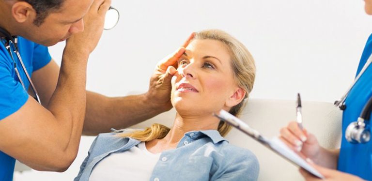 A woman having her eye examined by a doctor.