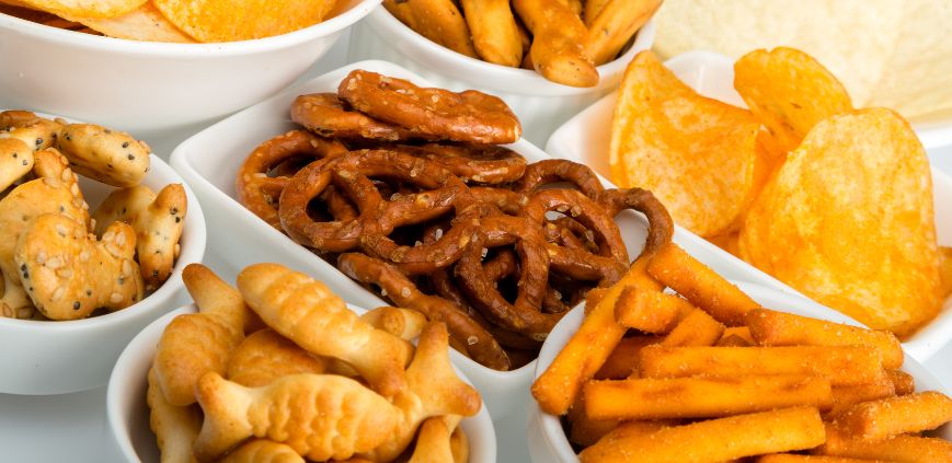 Bowls of snacks including pretzels, crackers and chips.